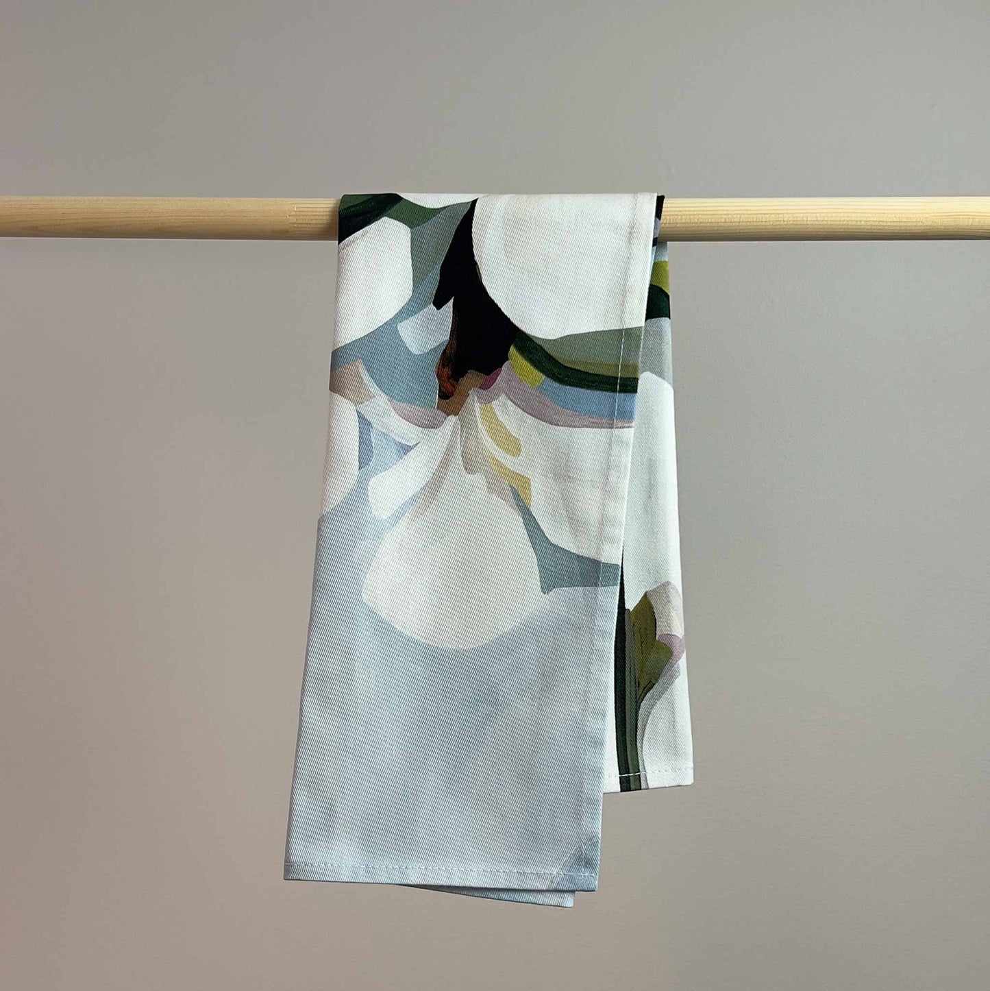 close up of hanging blue and white floral tea towel showing cotton texture and abstract floral print