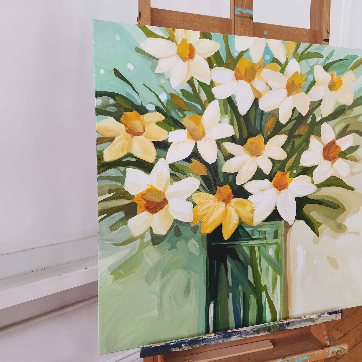 close up of a square floral painting of daffodils in a vase