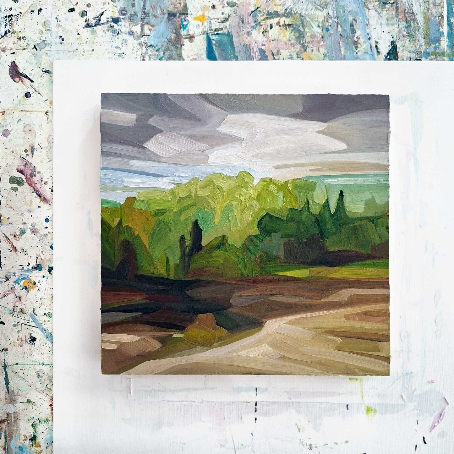 overhead view of an original oil painting on wood panel of a forest spring landscape with brown fields and a mauve grey sky