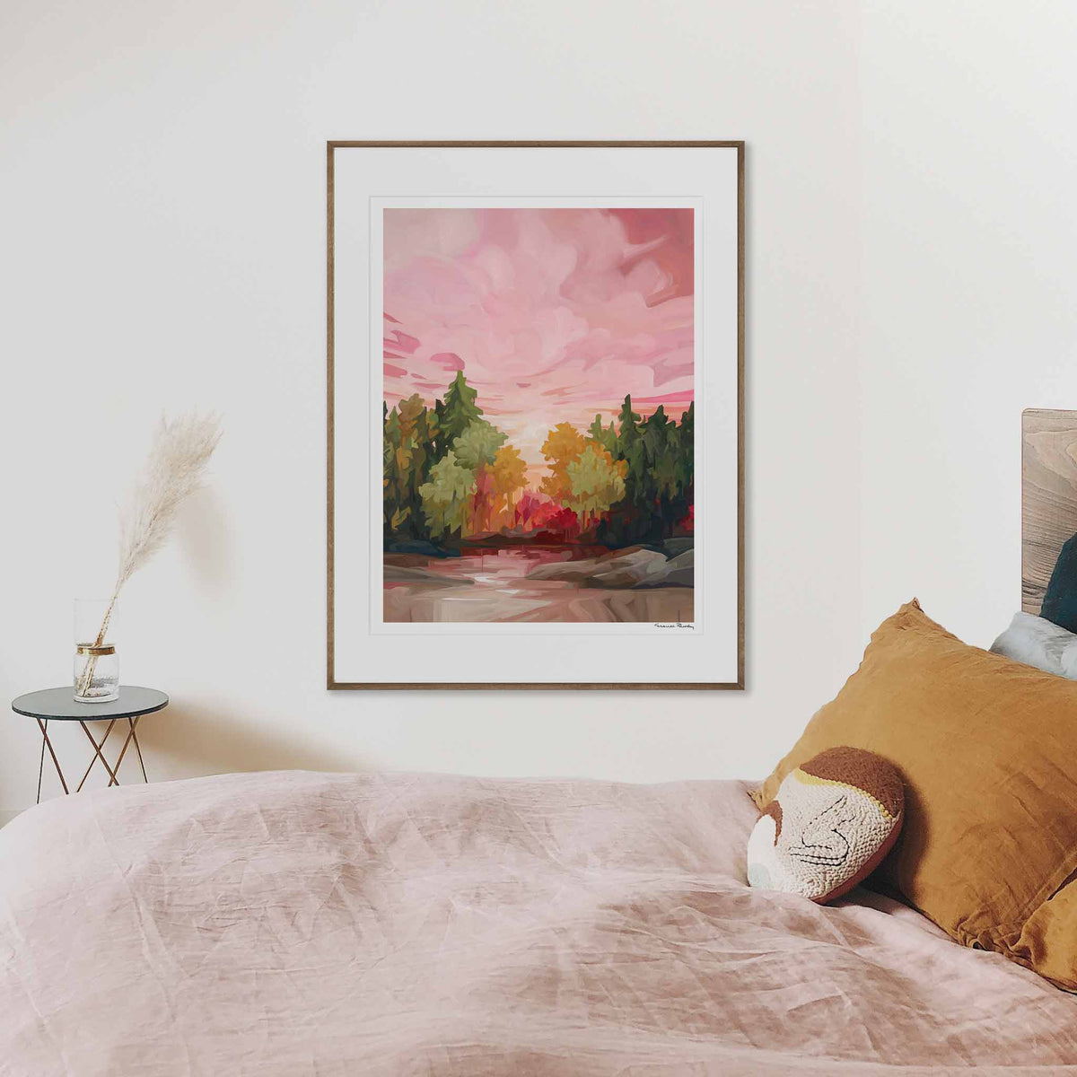 a large vertical art print of a autumn forest painting hanging in a bedroom by Canadian artist Susannah Bleasby