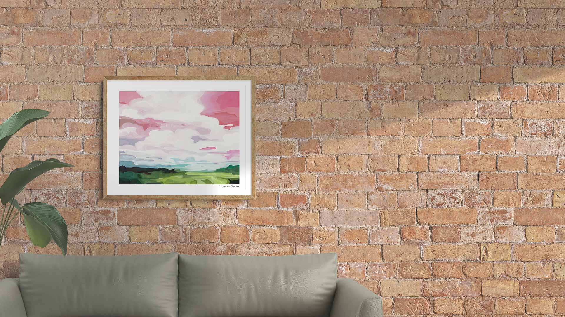 Pink abstract sky painting wall art print hanging on brick wall