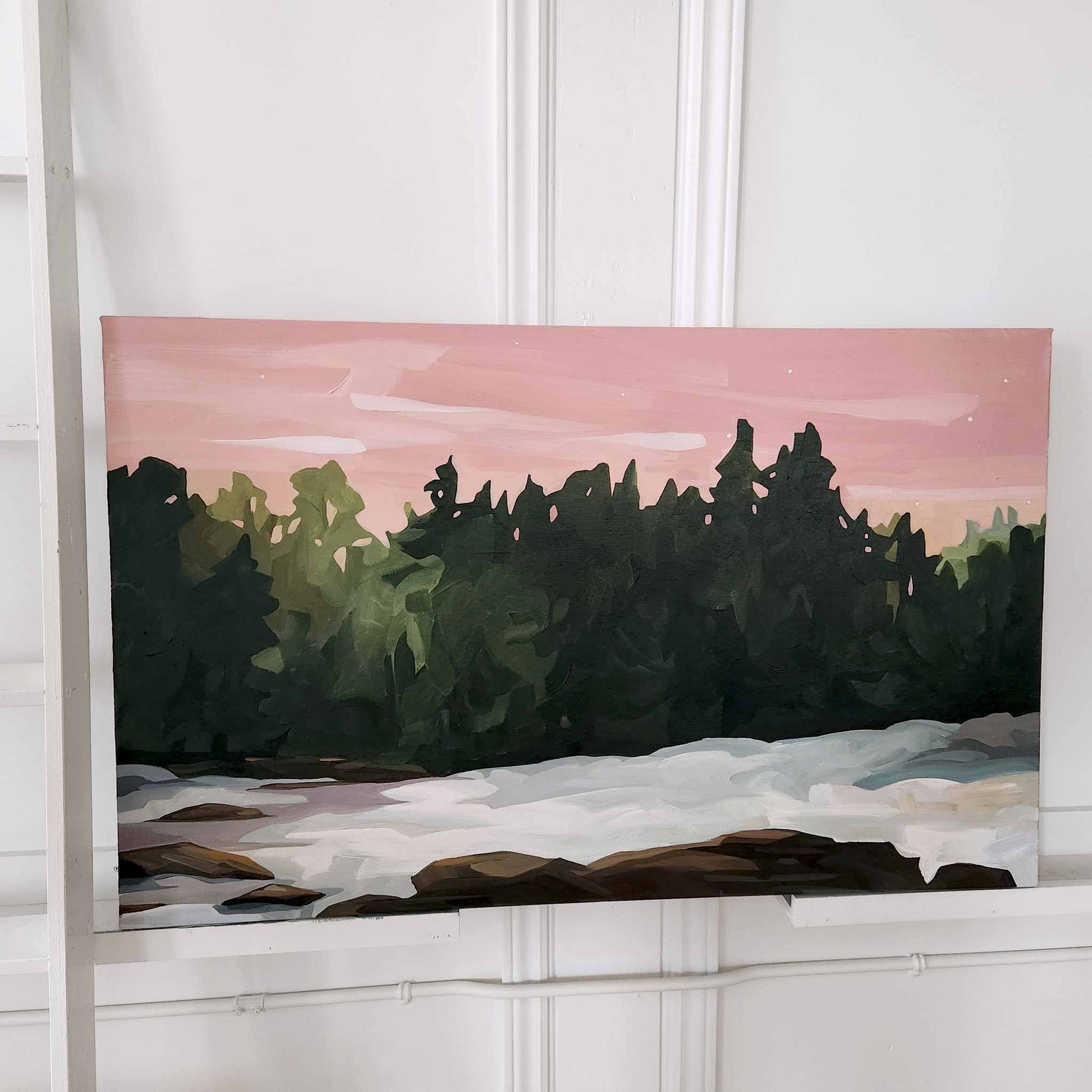 An acrylic landscape painting of a snowy forest scene where  light and shadows create depth and a pink sky adds a splash of colour