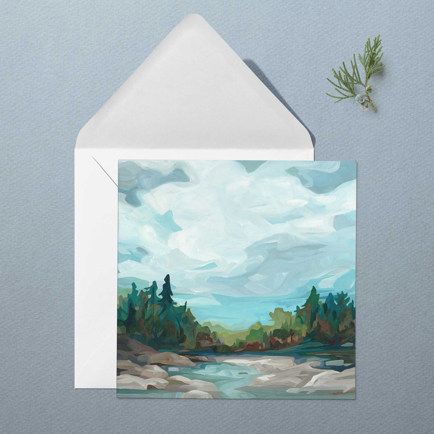 Landscape art greeting card with soft blue-grey skies, calm water, and endless forest beyond the shore