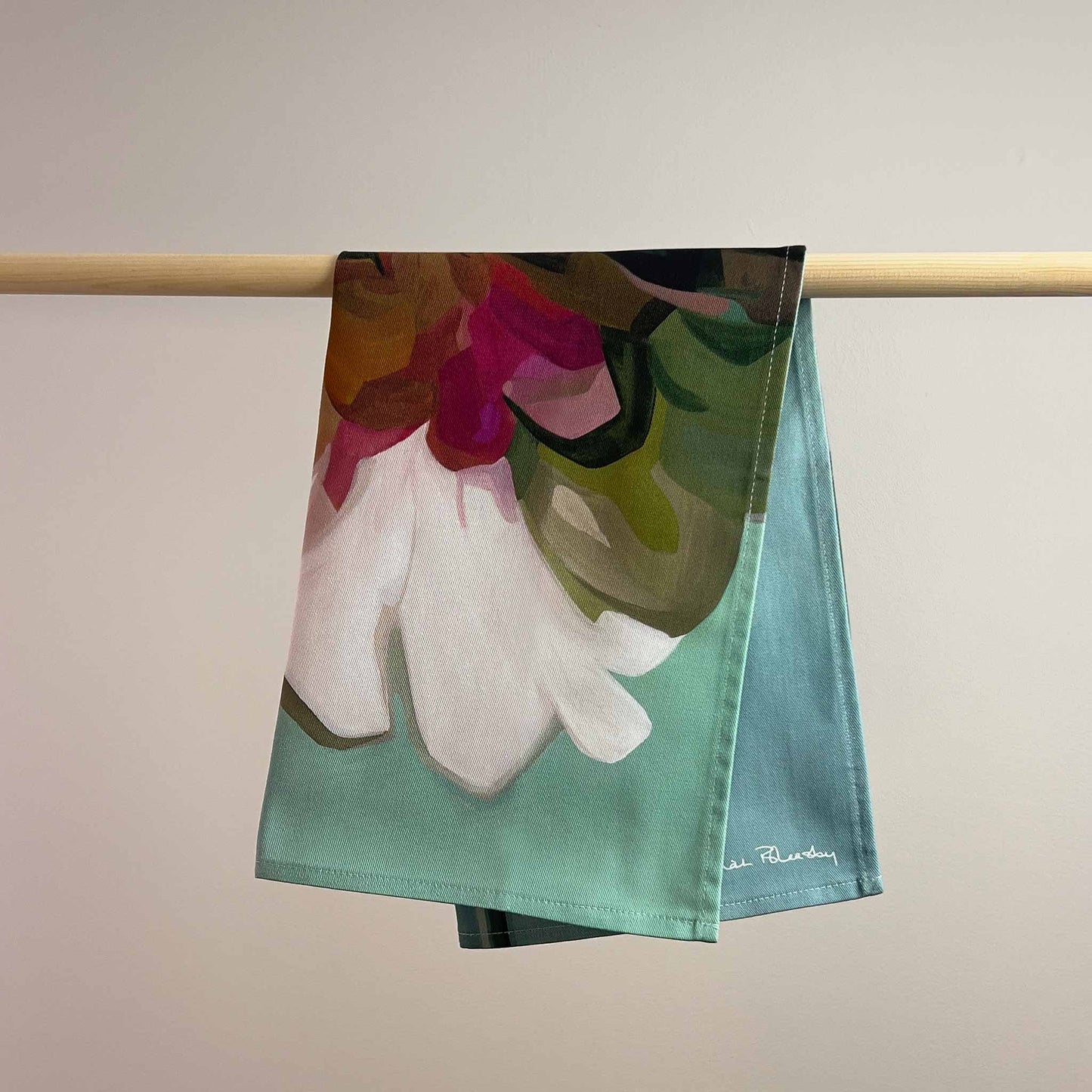 cotton tea towel with a white flower on a teal background