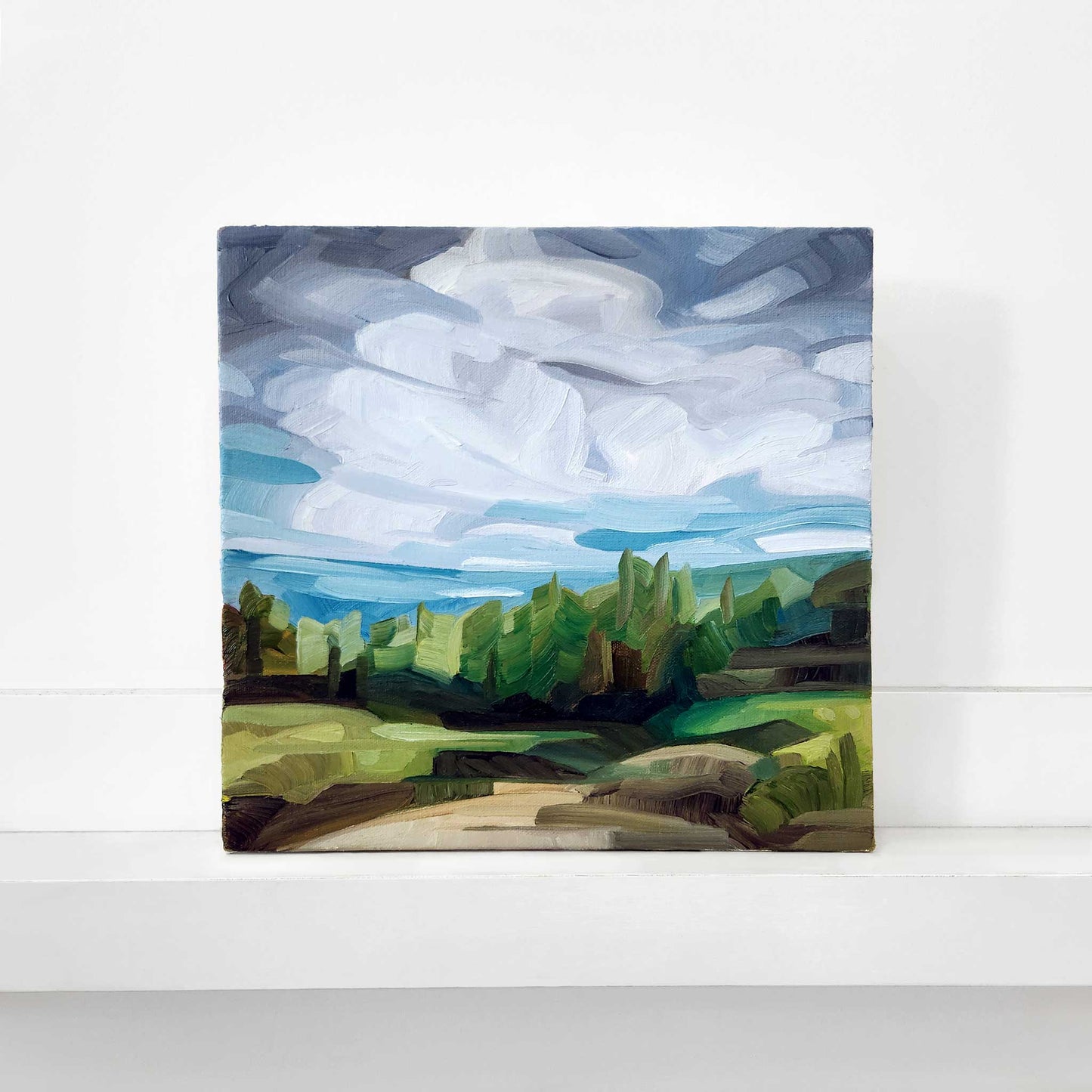 original oil painting of a woodland path with dramatic clouds a green forest and expressive brushstrokes