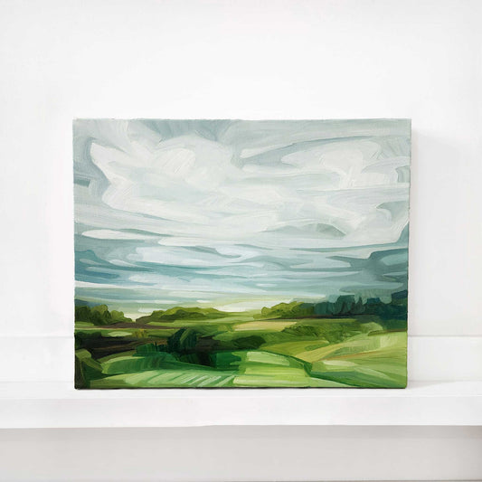 original oil painting of rolling green fields beneath a soft blue sky with sweeping clouds
