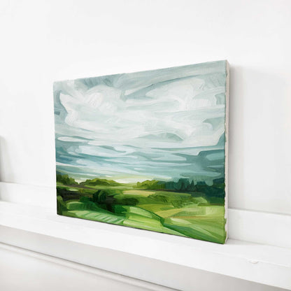 original countryside oil painting with lush green fields dramatic clouds and lush spring green colours
