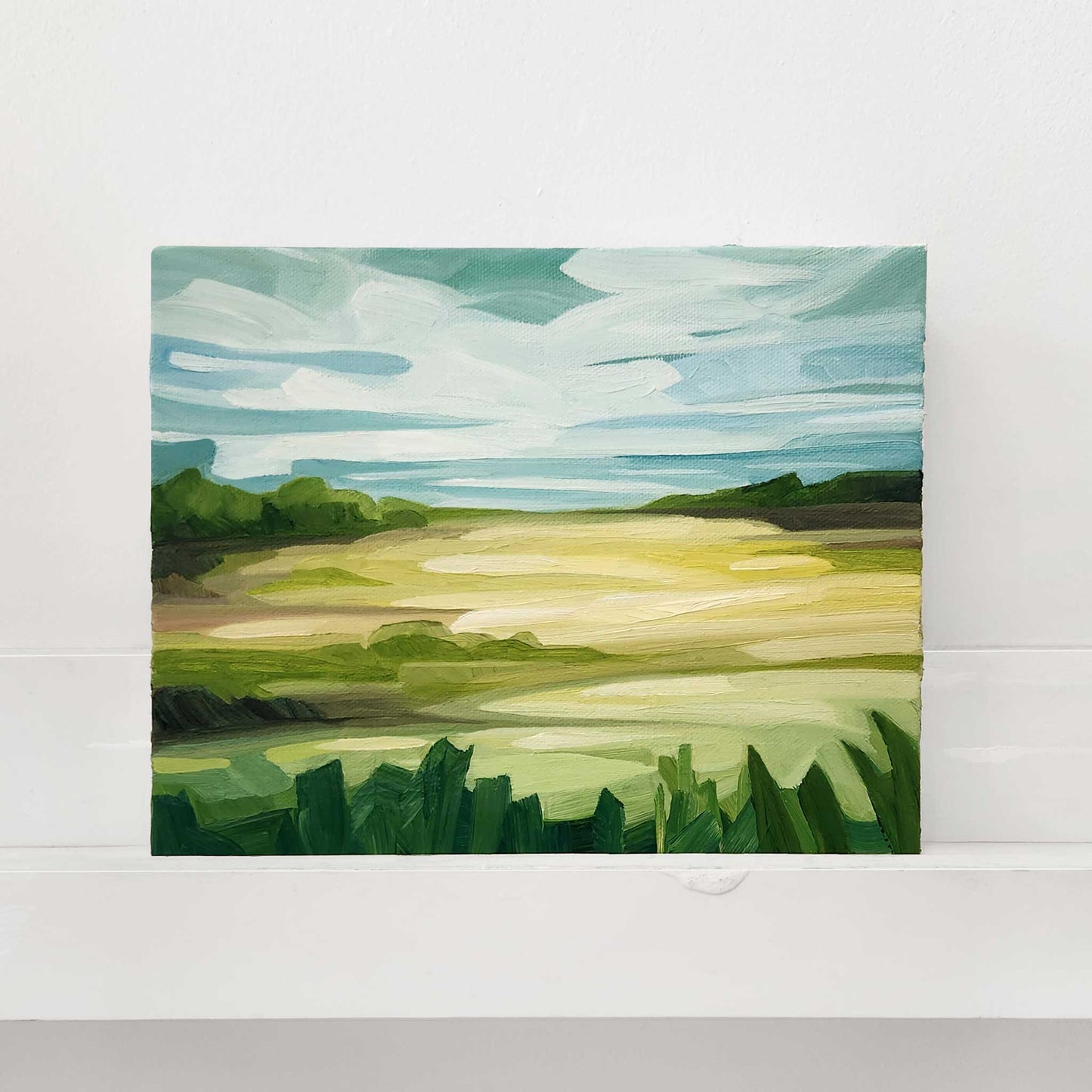 Original oil painting of green summer fields stretching beneath a bright open sky.