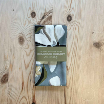 grey floral tea towel folded with a bellyband