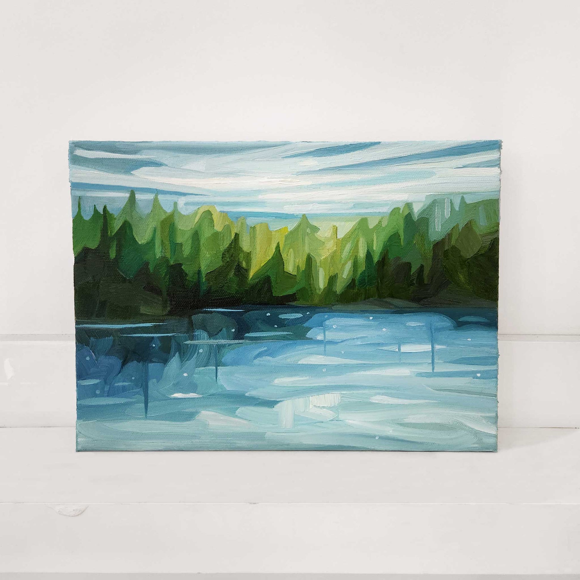 Original oil painting of a peaceful lakeside surrounded by forest.