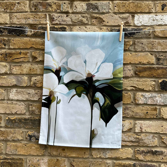 light blue floral cotton teal towel hanging against a brick wall