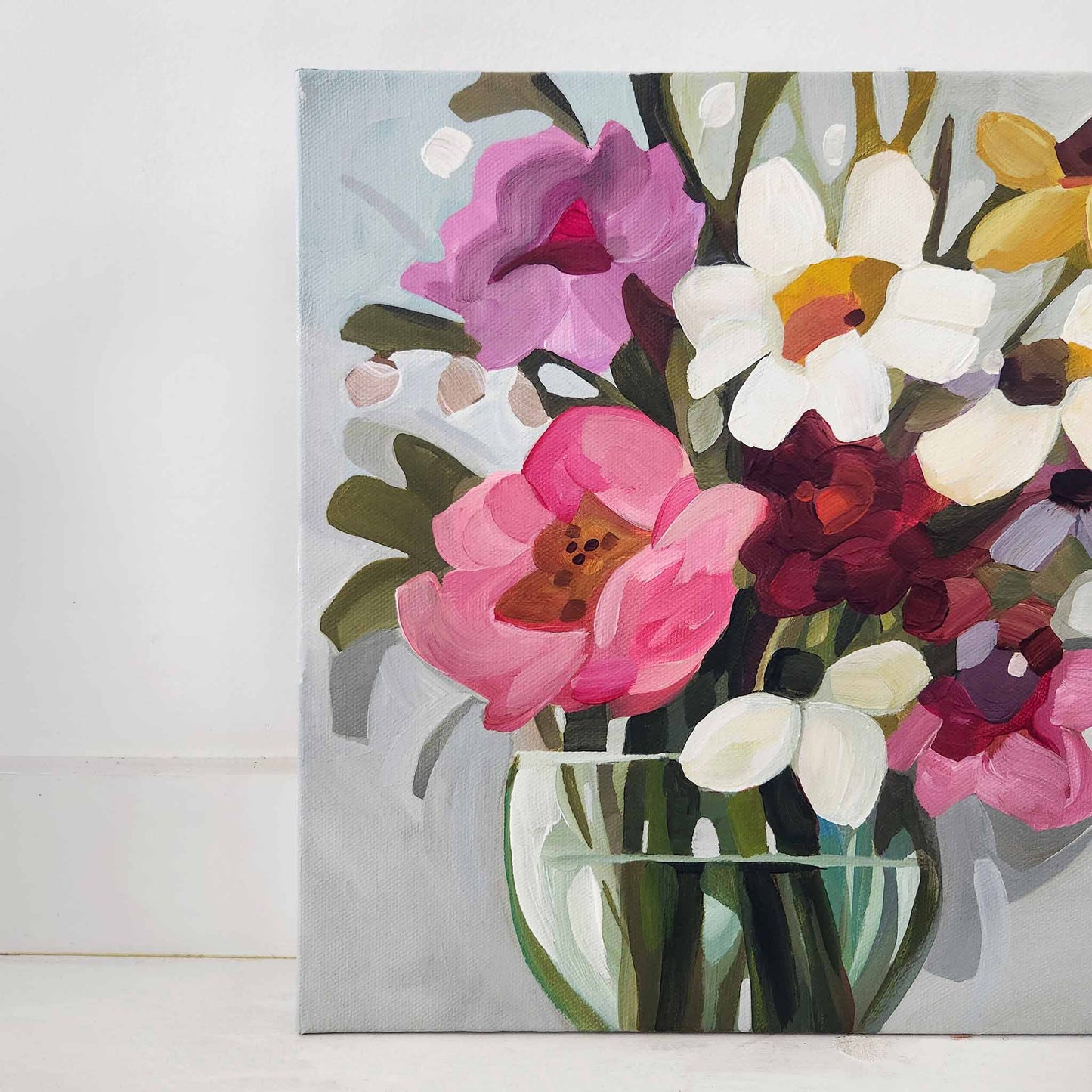 left side close up of bright floral bouquet painting on grey blue canvas