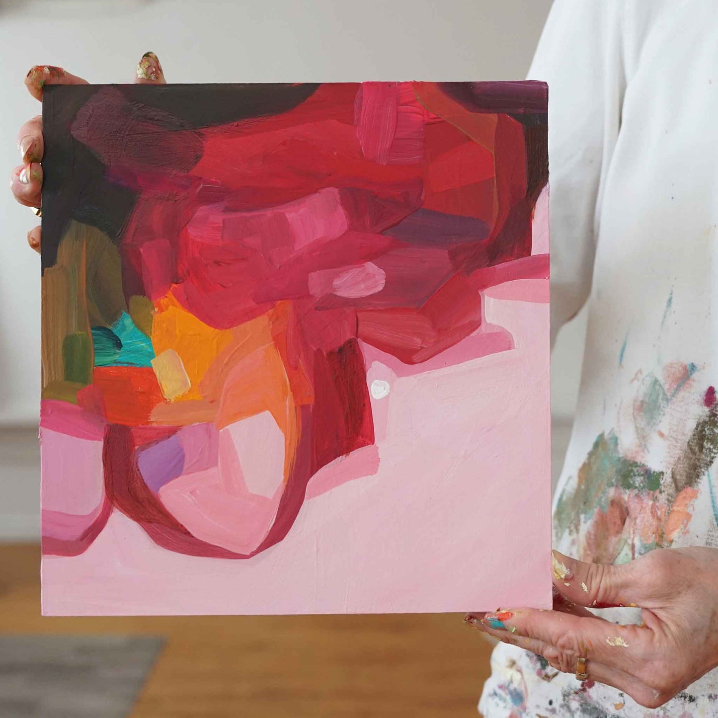 artist holding small red abstract painting