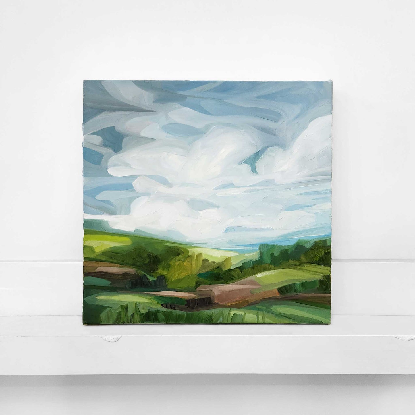 original oil painting of a pastoral landscape with blue skies and green fields in the countryside