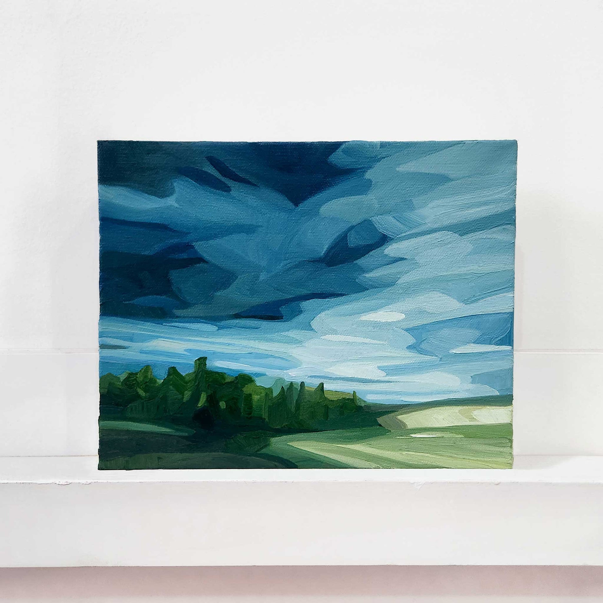 Original oil painting of a spring landscape with rain clouds gathering over rolling countryside.