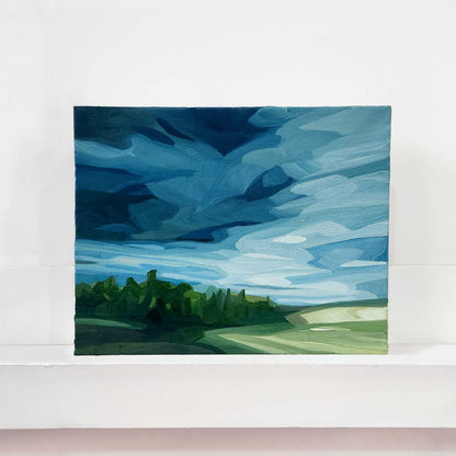 Original oil painting of a spring landscape with rain clouds gathering over rolling countryside.