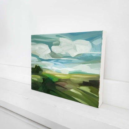 Summer countryside oil painting with vibrant green fields beneath a bright blue sky.