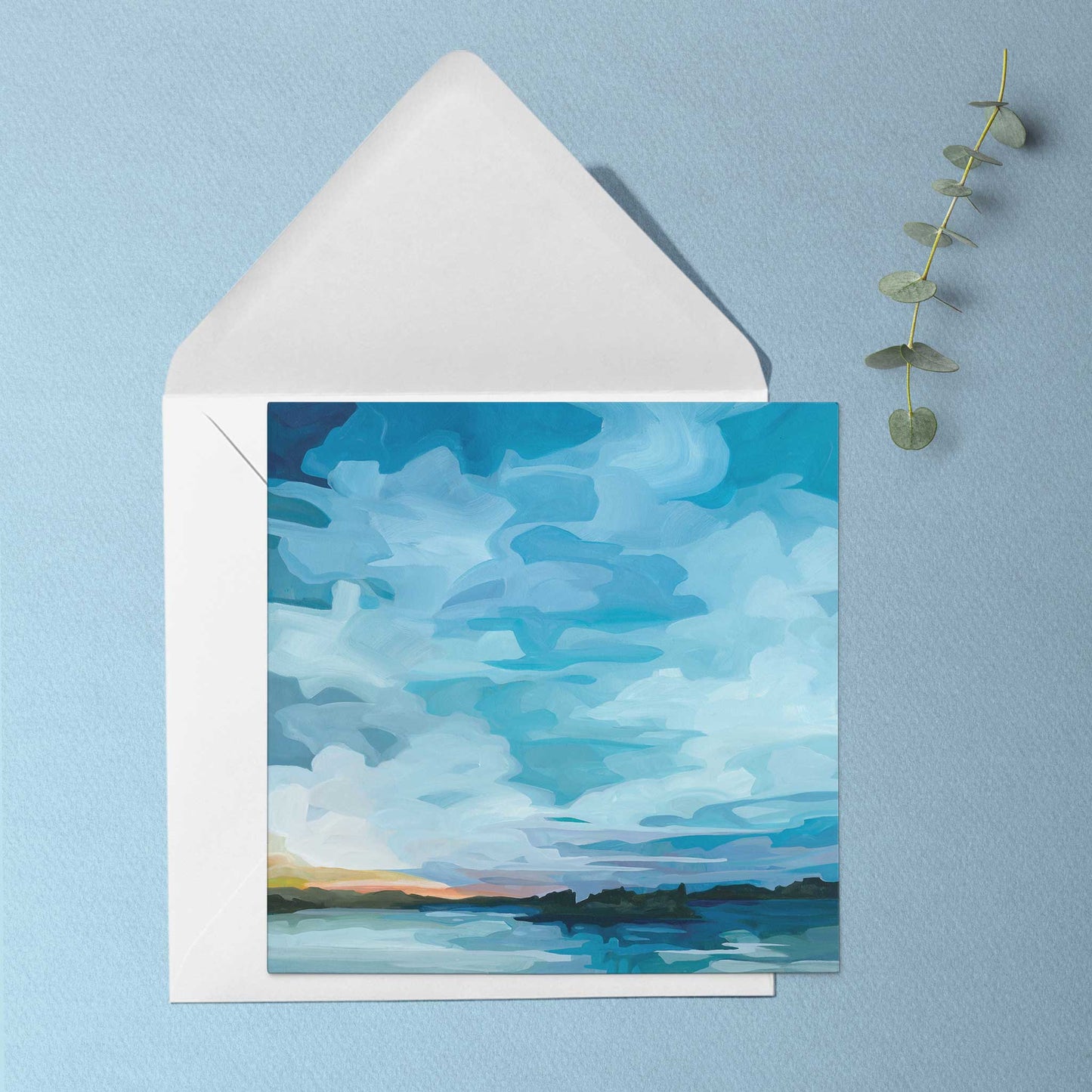 Nature inspired greeting card featuring glowing sunset light across still lake water beneath an impossibly blue evening sky