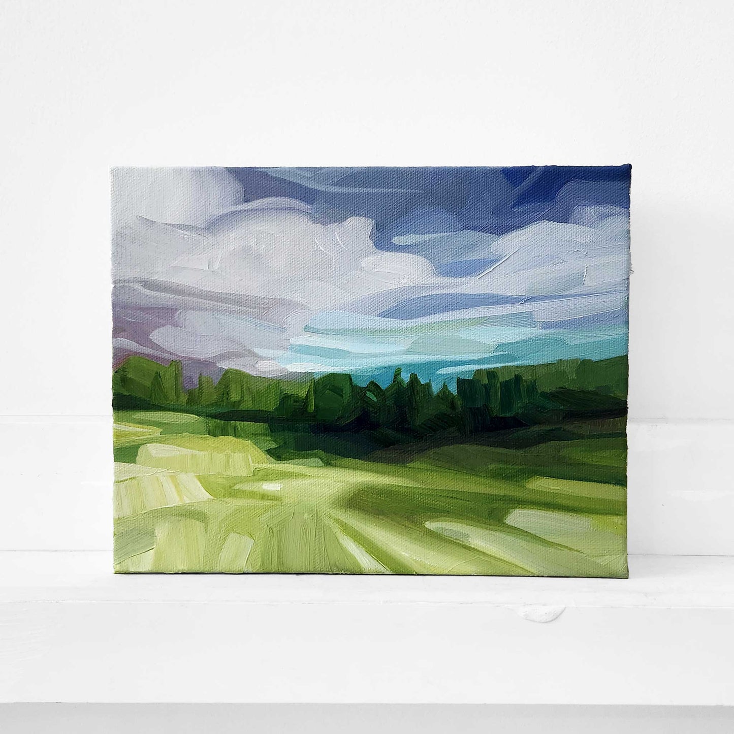 Woodland landscape oil painting with distant hills beneath a dramatic sky.