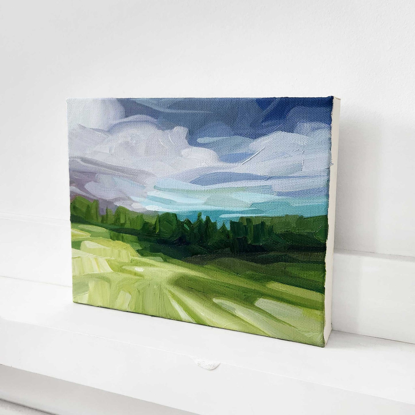 Original oil painting of a woodland landscape with a distant horizon and dramatic sky.