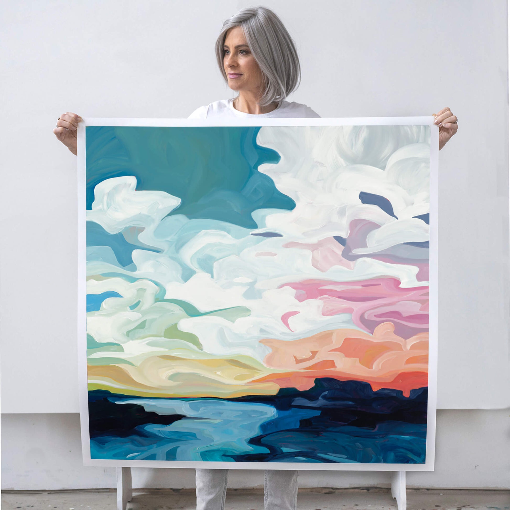 Canadian artist Susannah Bleasby holding a large colourful abstract fine art print with a beautiful dynamic evening sky