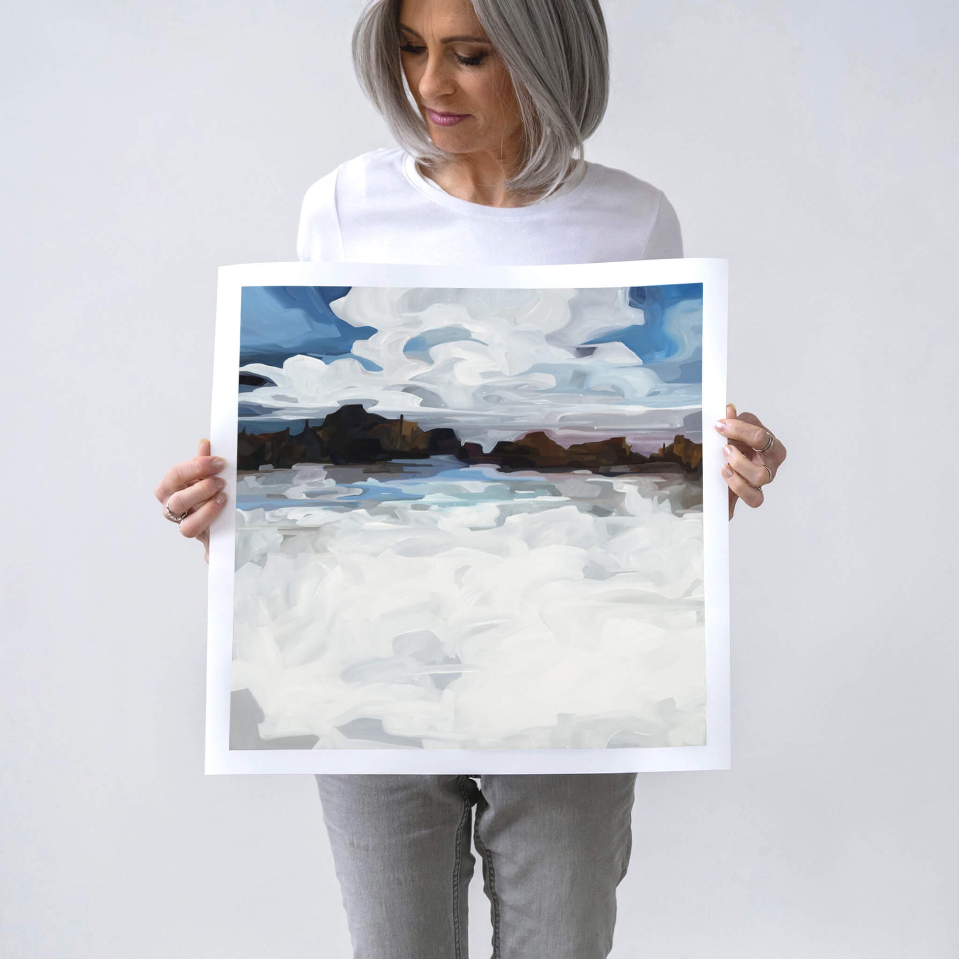 Canadian artist Susannah Bleasby holding a fine art print of Winterlake an abstract winter landscape painted in a winter palette