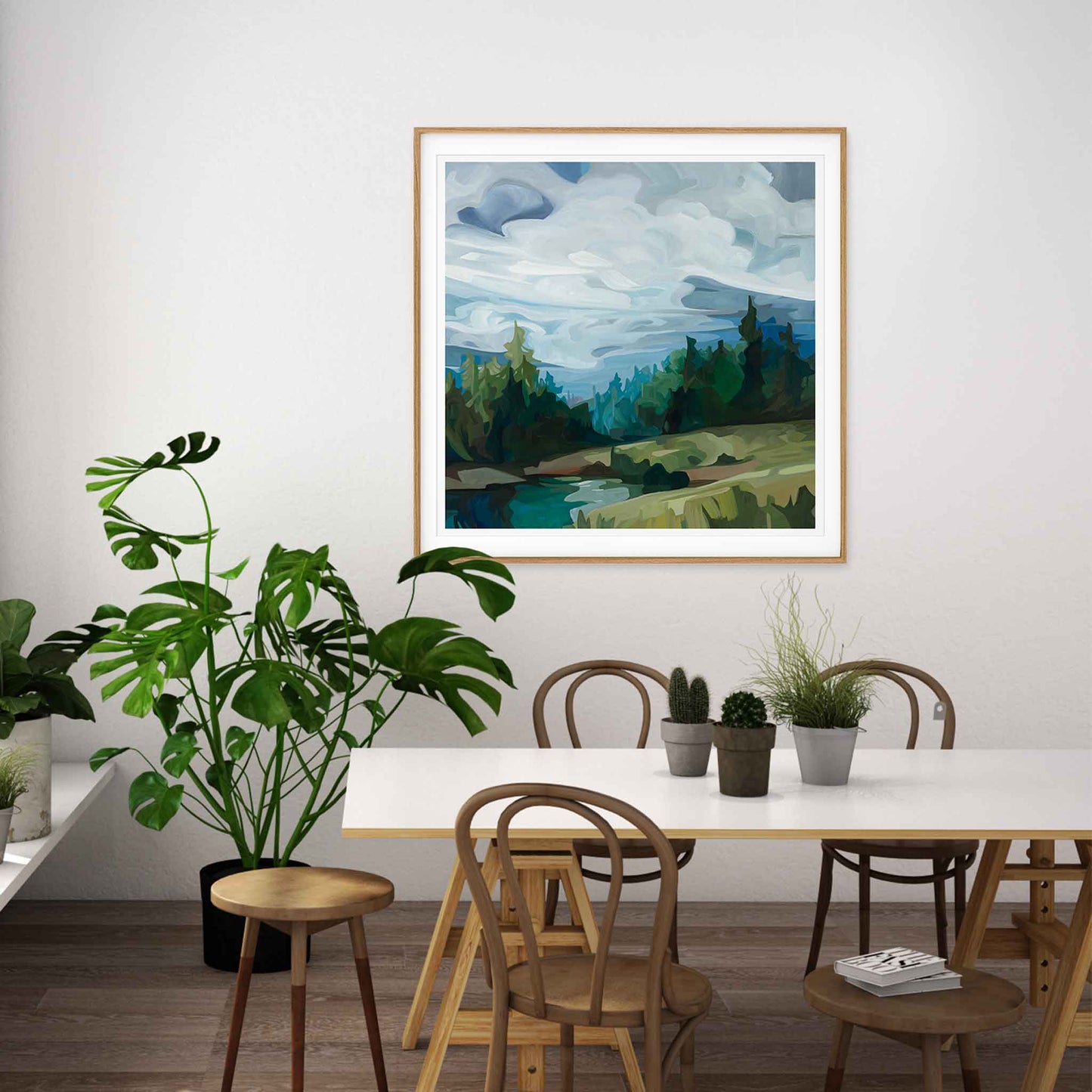 large square art print of a hillside mountain painting in a breakfast room