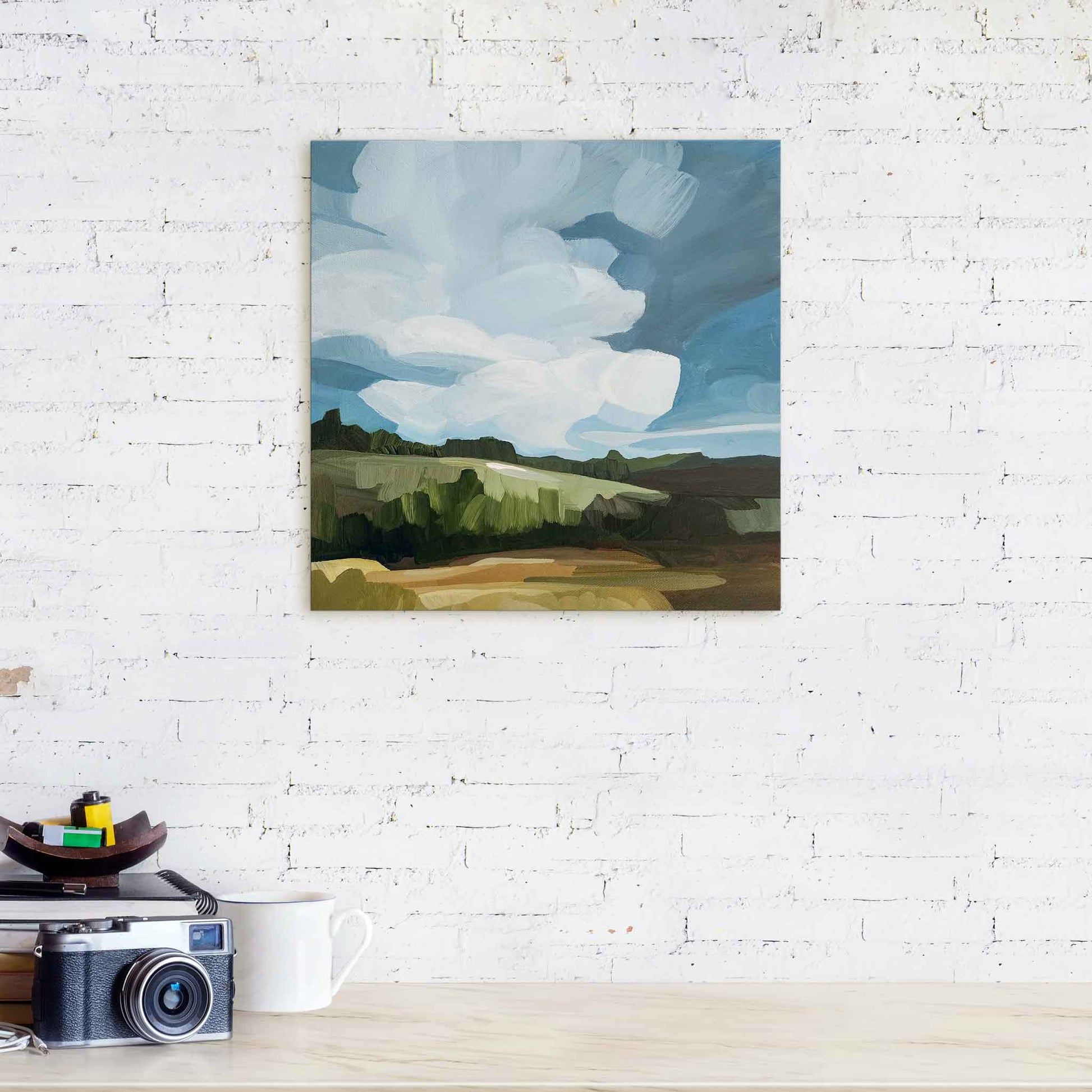 abstract landscape painting with big blue sky original art displayed on white brick wall