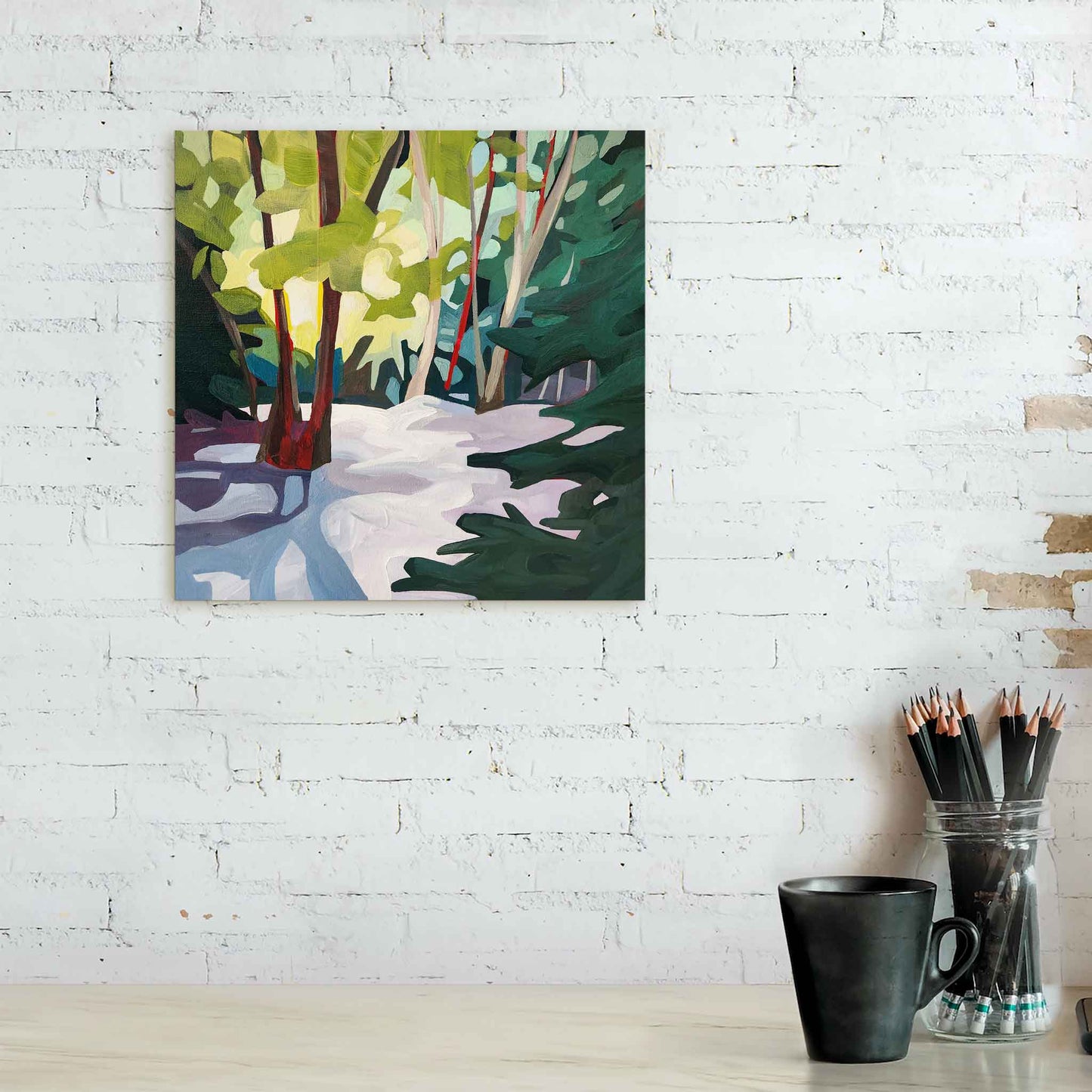 abstract forest painting of a lush forest in winter hanging over counter against a white brick wall