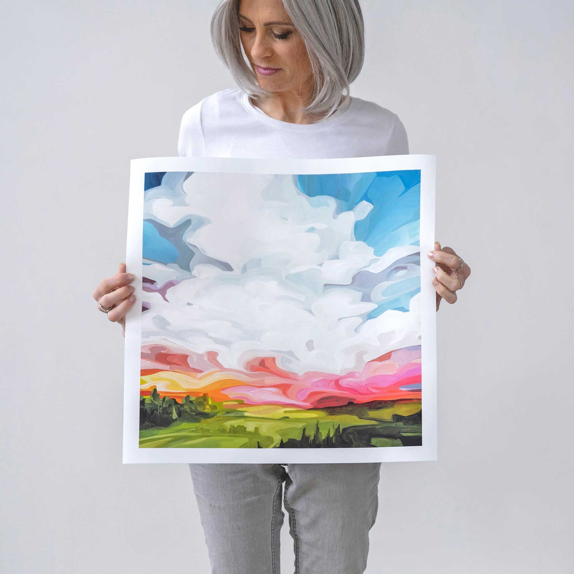 Canadian artist Susannah Bleasby holding sky painting square art print of a vibrant abstract sky