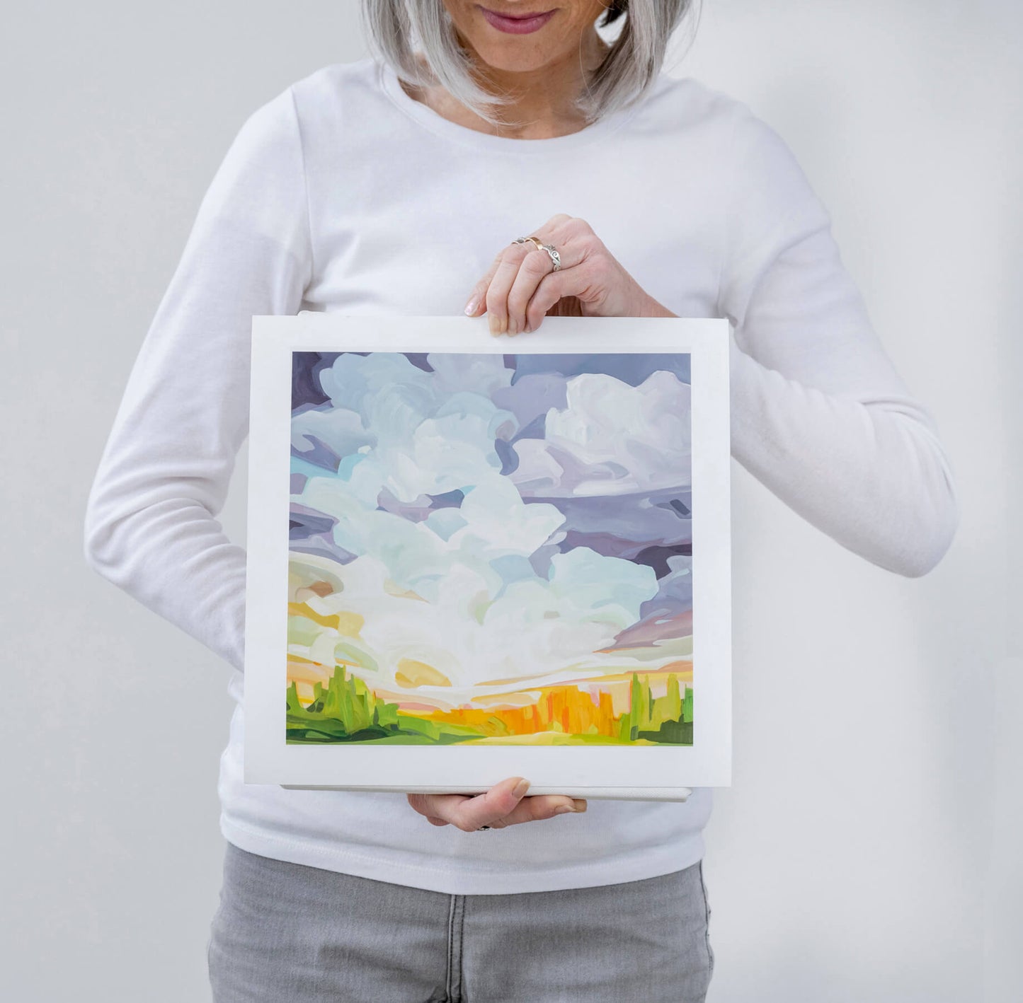 Canadian artist Susannah Bleasby holding small square acrylic sky painting art print